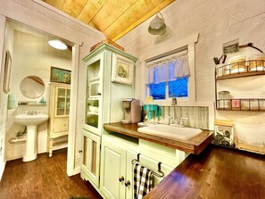 Una cocina con encimera de madera, un lavamanos y un ventanal con vistas.