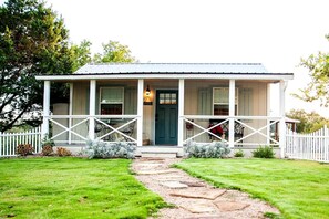 A house with a porch, a front door, and a pathway leading to the entrance.