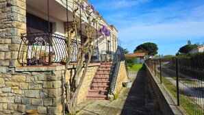 A stone building with a balcony, a staircase, and a narrow pathway. - L'oustal- Oc Keys- Family home, private garden, close to freeway (Bram)