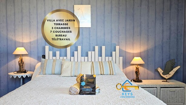 A bedroom with a bed, two bedside tables, a wall-mounted artwork, and a sign with hotel details. - L'oustal- Oc Keys- Family home, private garden, close to freeway (Bram)