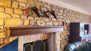 A stone wall with a fireplace, a wooden mantel, and a leather couch. - L'oustal- Oc Keys- Family home, private garden, close to freeway (Bram)
