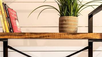 A wooden shelf with a potted plant and books.