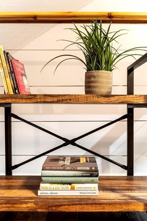 Una estant de fusta amb una planta en test i llibres.