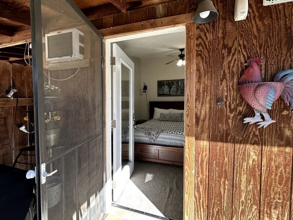 Un dormitorio con cama, ventilador de techo y una decoración de gallo de madera.