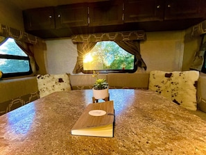 A kitchen with a granite countertop, a small potted plant, and a book on the table.