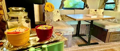 A kitchen with a dining area, a green chair, and a tray with bowls.