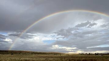 Un paisaje con un arcoíris que se extiende sobre un cielo nublado.