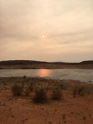 Eine Wüstenlandschaft mit einem Gewässer, das die Sonne reflektiert.