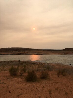 A desert landscape with a body of water reflecting the sun. - Modern Cubed Cabin Accommodation for a Getaway near the Grand Canyon, Arizona (Page)