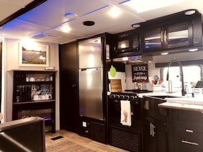 A modern kitchen with a stainless steel refrigerator, a stove, and a microwave.