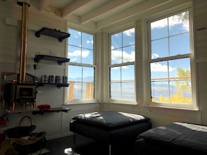 Ein Zimmer mit zwei Betten, einem Kamin und großen Fenstern mit Bergblick.