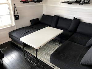 A modern room with a black sofa, a white table, and a patterned rug.