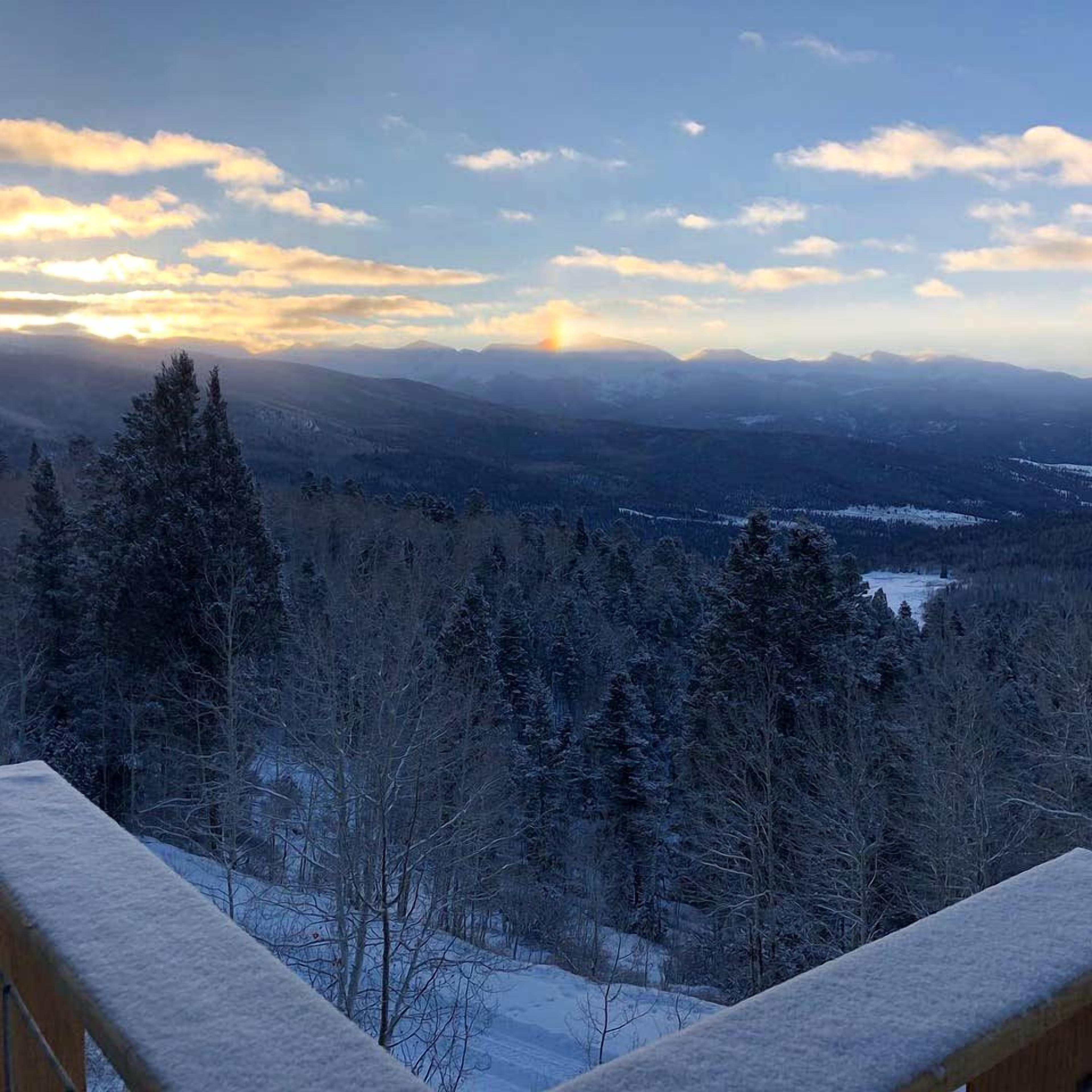 A snowy landscape with mountains and a clear sky.