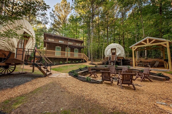 A rustic cabin with a deck and a covered outdoor seating area.
