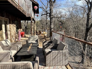 Une terrasse extérieure aménagée avec des meubles en osier, une table à manger et une nappe rouge.