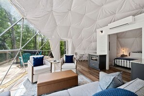 A tented accommodation with a wooden deck, seating area, and a kitchenette. - Fully-Equipped Lake Dome with Beautiful Interior and Exterior in Tennessee (Smithville)