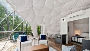 Un alojamiento con carpa, terraza de madera, zona de estar y kitchenette.