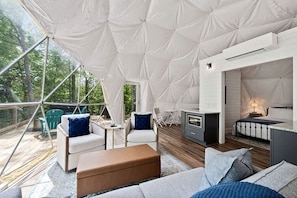 A tented accommodation with a wooden deck, seating area, and a kitchenette. - Fully-Equipped Lake Dome with Beautiful Interior and Exterior in Tennessee (Smithville)