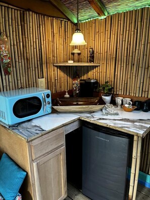 Una cucina compatta con forno a microonde, macchina del caffè e lavastoviglie.