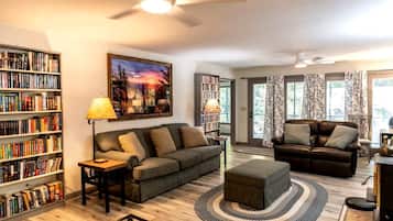 A living room with two sofas, a coffee table, a bookshelf, and a painting on the wall.