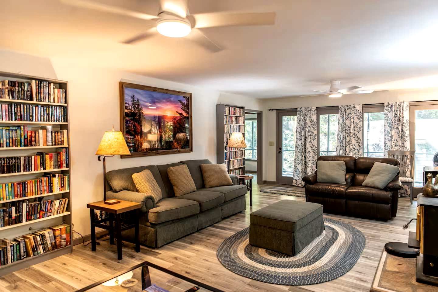 A living room with two sofas, a coffee table, a bookshelf, and a painting on the wall.