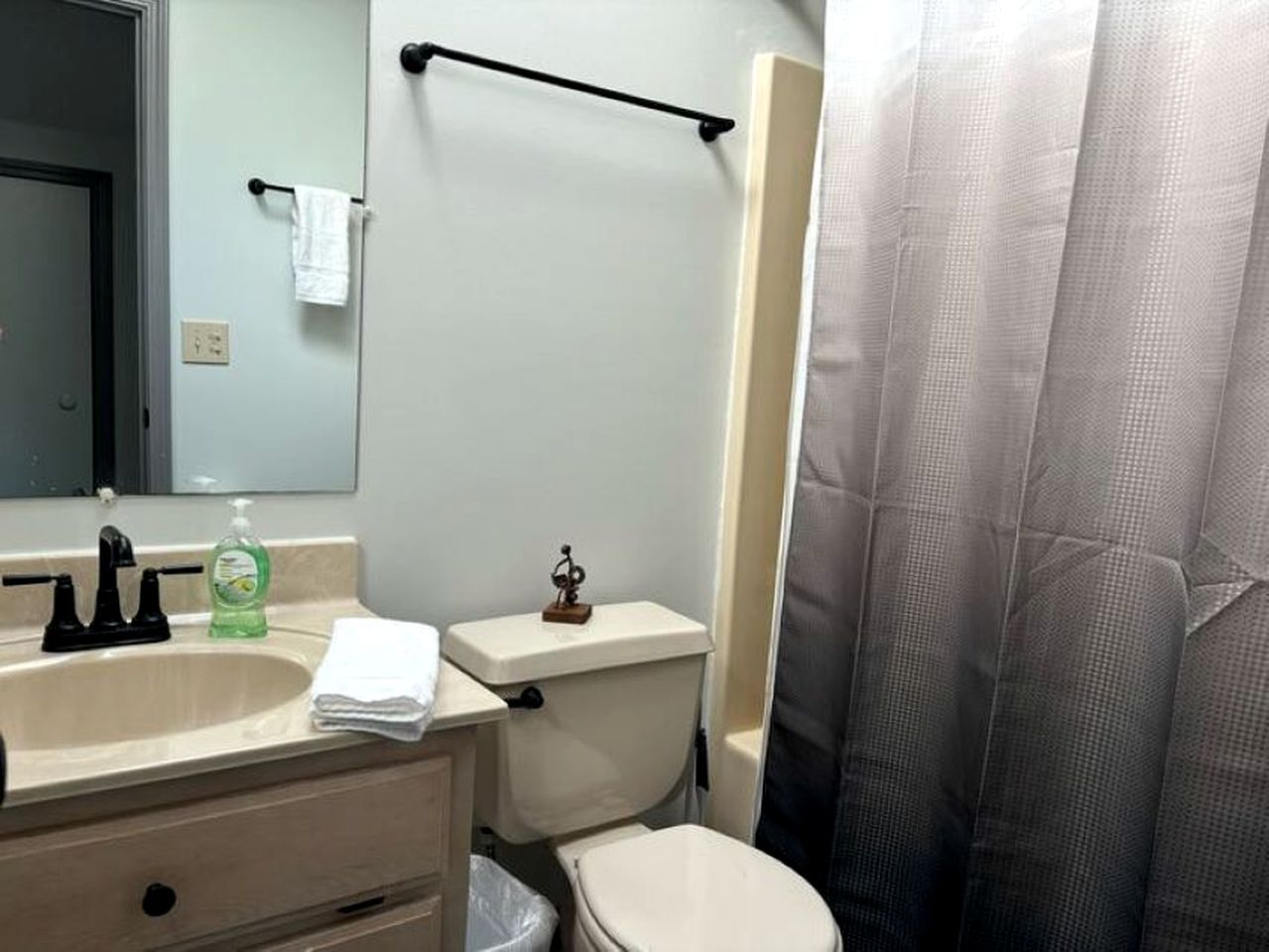 A bathroom with a sink, toilet, and shower curtain.