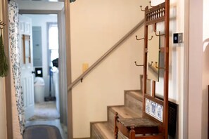 A staircase with a wooden handrail and a mirror with a plaque. - Modern Cabin with Gorgeous Porch with Stunning Views in Suches, Georgia (Suches)
