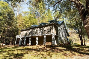 A rustic cabin with a porch, surrounded by trees. - Modern Cabin with Gorgeous Porch with Stunning Views in Suches, Georgia (Suches)