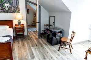 A room with a bed, a desk with a foosball table, a chair, and a lamp. - Modern Cabin with Gorgeous Porch with Stunning Views in Suches, Georgia (Suches)
