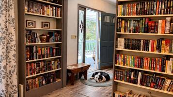 A home library with bookshelves, a wooden bench, and a dog.