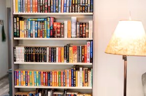A bookshelf filled with books and a floor lamp. - Modern Cabin with Gorgeous Porch with Stunning Views in Suches, Georgia (Suches)