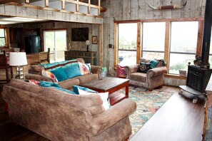 A rustic interior with a sofa, armchairs, a coffee table, and a fireplace.