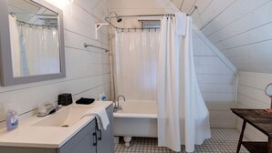 A bathroom with a bathtub, a sink, a mirror, and a shower curtain. - Secluded Cabin on Suches Creek and in the National Forest for a Relaxing Georgia Getaway (Suches)
