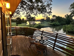 A wooden deck with a table and chairs overlooking a body of water. - Gorgeous Tree House Rental with Lake Views for Glamping in Texas (Willis)