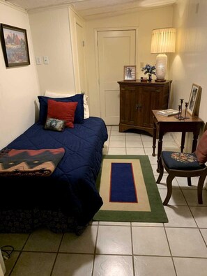 A bedroom with a bed, a wooden cabinet, a chair, a lamp, and a rug. - Clear River Cabin on the Medina River in Bandera, Texas (Bandera)