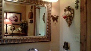 A bathroom with a sink, mirror, and decorative items.