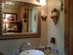 A bathroom with a sink, mirror, and decorative items. - Pet-Friendly Cabin Rental with Creekside Views near Bandera, Texas (Pipe Creek)