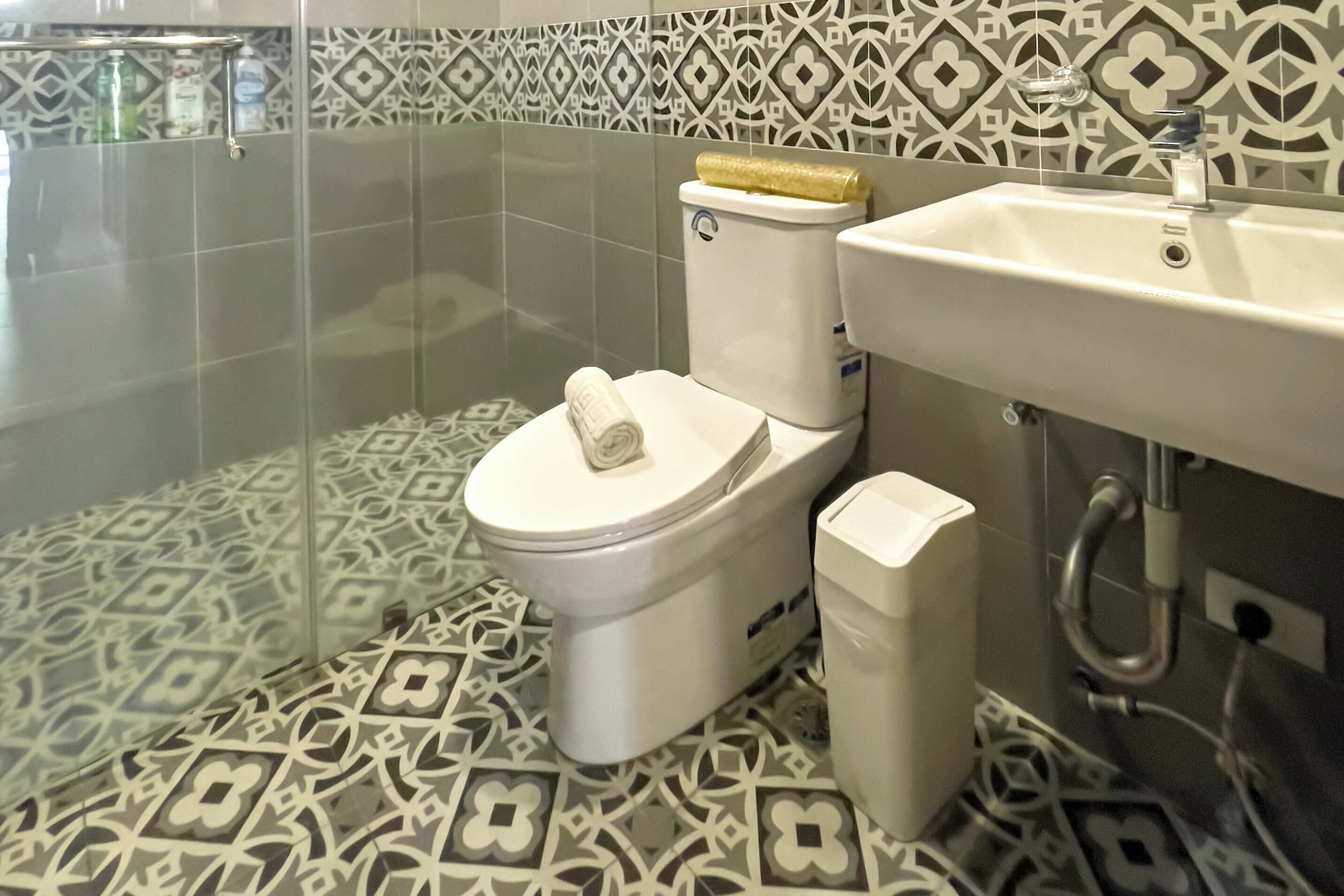 Un baño con inodoro, lavabo y zona de ducha.