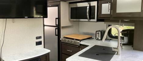 Frigorífico, placa de cocina, cafetera o tetera y utensilios de cocina