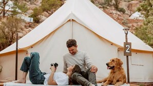 Une tente avec un panneau indiquant un numéro, une personne prenant une photo et un chien.