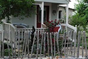 A house with a porch, a fence, and a garden.