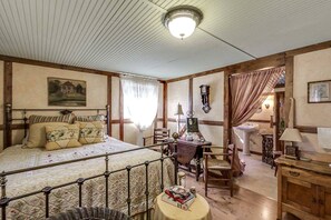 Quarto com cama, escrivaninha, cadeira, abajur e relógio na parede.