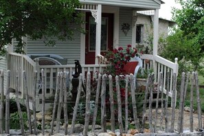 A house with a porch, a fence, and a garden.