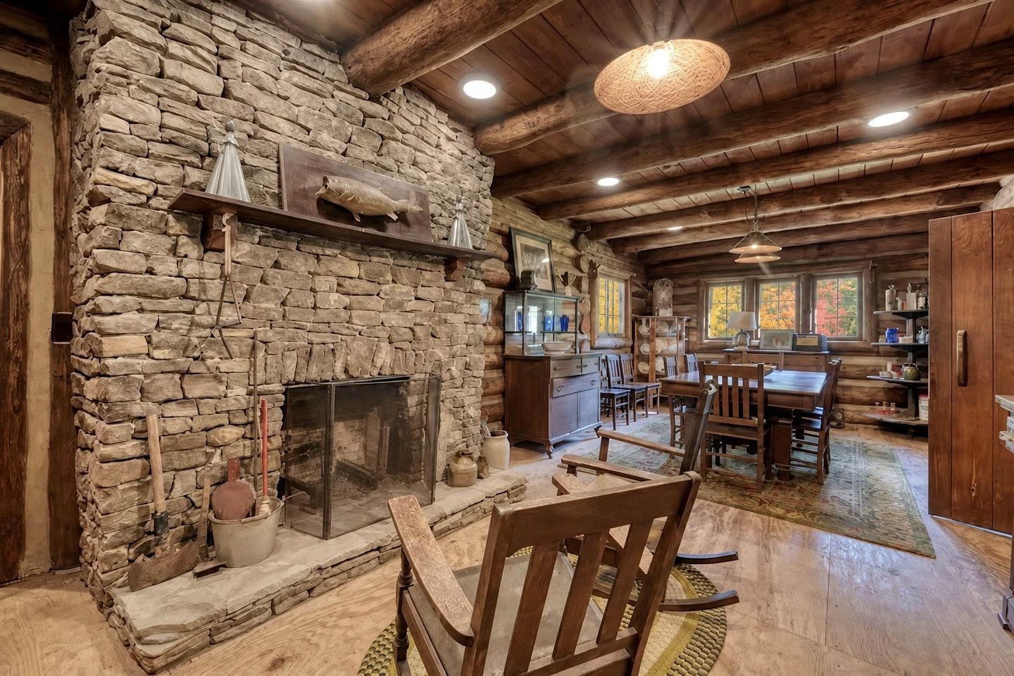 Un intérieur rustique avec une cheminée en pierre, des meubles en bois et un coin repas.