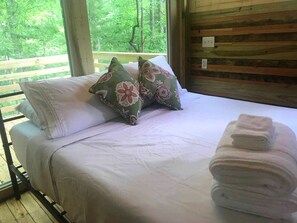 A bed with pillows and a stack of towels.
