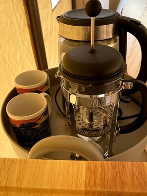 A coffee maker with a transparent carafe and a black lid, accompanied by two cups with a turtle design. - Luxurious Tent for a Romantic Getaway in Mountain View Village, Hawaii (Volcano)