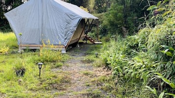 A tent set up in a natural environment with a path leading to it.