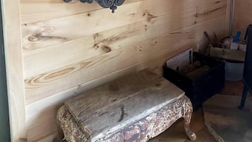 Un intérieur en bois avec un banc, une étagère et un sac suspendu.