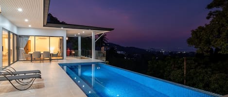 Een buitenzwembad en ligstoelen