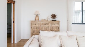 Un salon avec un meuble en bois, une lampe et un objet décoratif posé sur le dessus.